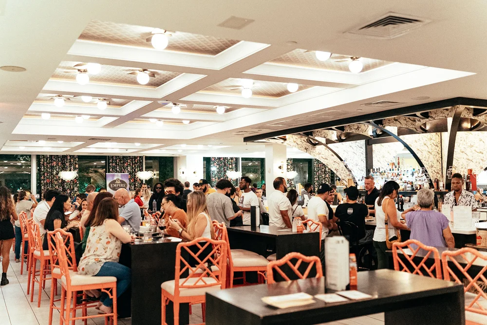 Inside Mia Market · guests at the central bar inside the Design District food court Inside Mia Market · guests at the central bar inside the Design District food court